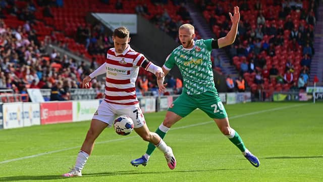 Doncaster's Luke Molyneux fends off Swindon's Frazer Blake-Tracy.