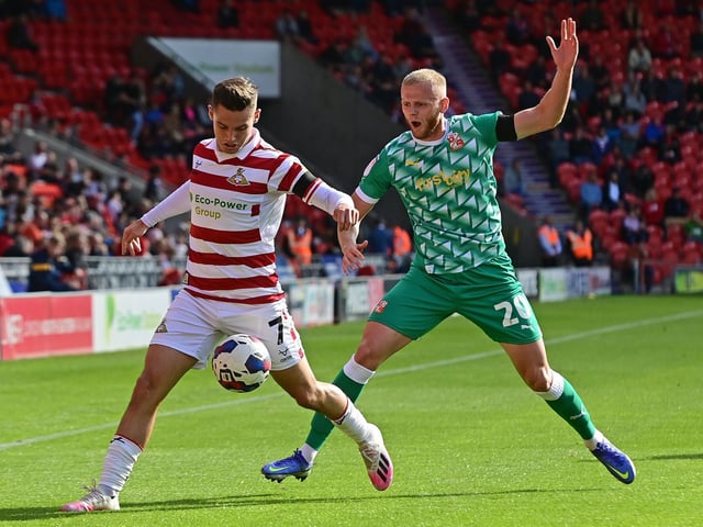 Doncaster's Luke Molyneux fends off Swindon's Frazer Blake-Tracy.