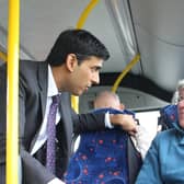 Rishi Sunak speaks with a bus passenger.