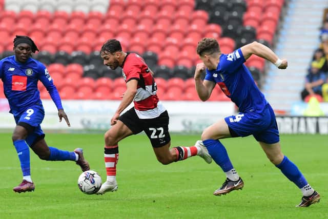 Doncaster Rovers' Tyler Roberts dribbles past Harrogate Town's Abraham Odoh.