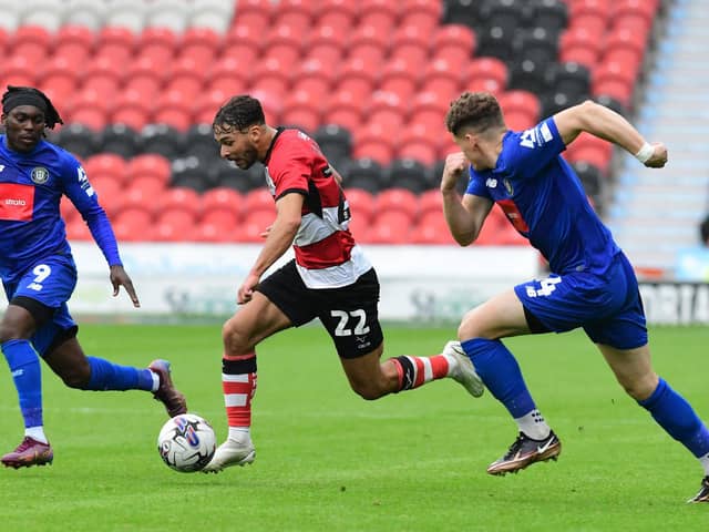 Doncaster Rovers' Tyler Roberts dribbles past Harrogate Town's Abraham Odoh.