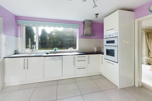 The kitchen with fitted units and integrated appliances has a window with garden views.