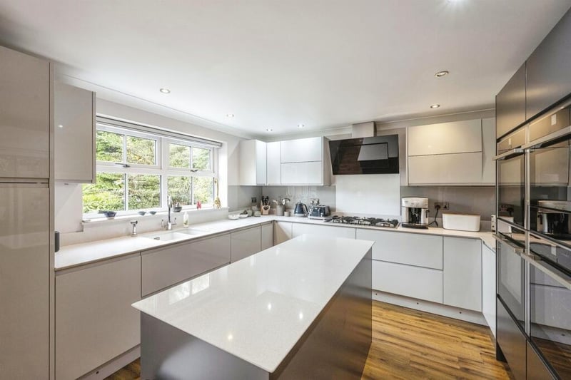 The contemporary style fitted kitchen has a central island and is open plan to family and dining areas.