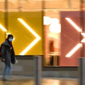 A pedestrian wearing a protective face covering walks past a store in central Sheffield (Photo by OLI SCARFF/AFP via Getty Images)