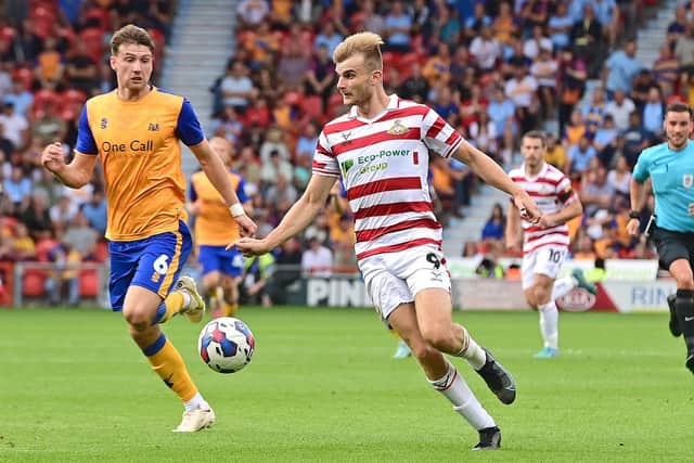 Doncaster's George Miller looks to get past Mansfield's Riley Harbottle.