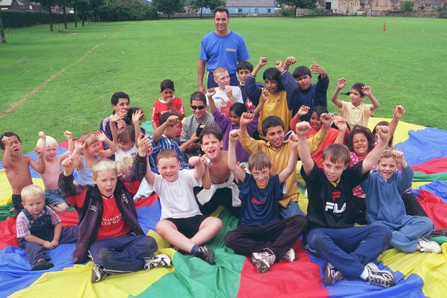 Pictured on Coleridge Road playing fields, where Sheffield City Council Community Recreation and the Out of School Network were holding their 1999 children's playscheme. Seen are some of the children with Mr Goddard, one of the scheme organiser.