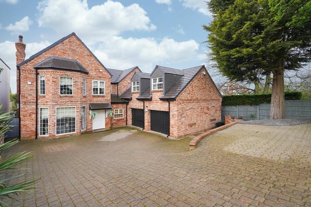 A view of the front of the property, with its double garage and courtyard parking.