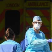 Doctors wearing protective equipment are seen loading a patient in to an ambulance (Photo by Peter Summers/Getty Images)