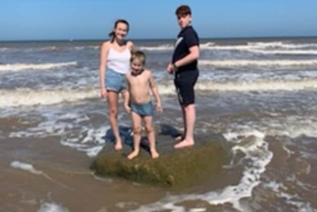 Josh Quarton and Halle Roberts on the rock they found the shell under on the east coast, with their younger brother