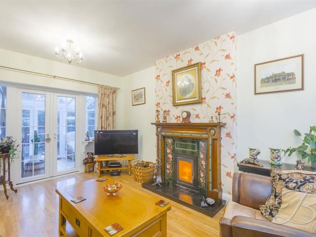 Another photo of the extra living room, with its feature fireplace and patio doors leading to the conservatory. A comfortable space for family and friends to enjoy.