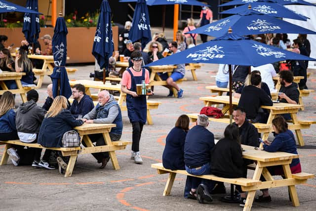 Members of the public enjoy their first drink in a beer garden (Photo by Jeff J Mitchell/Getty Images)
