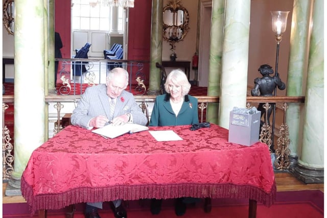 The Royal couple sign the visitor's book at the Mansion House.