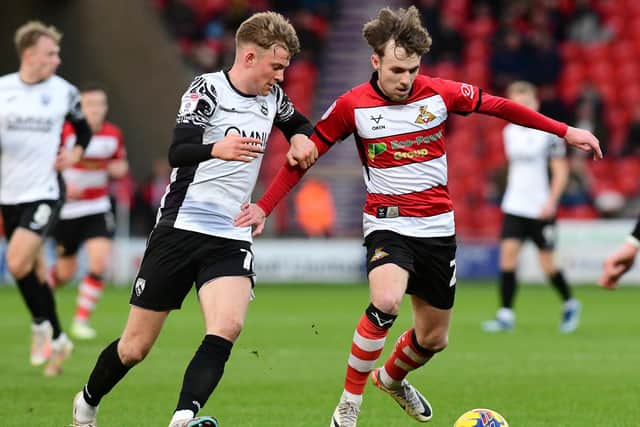 Doncaster's Kyle Hurst battles with Morecambe's JJ McKiernan for the ball. (Picture:Andrew Roe/AHPIX LTD)