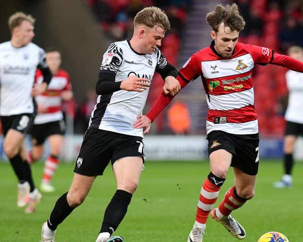 Doncaster's Kyle Hurst battles with Morecambe's JJ McKiernan for the ball. (Picture:Andrew Roe/AHPIX LTD)