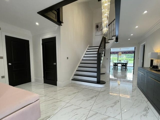More of the impressive hallway, with feature staircase rising to the first floor.