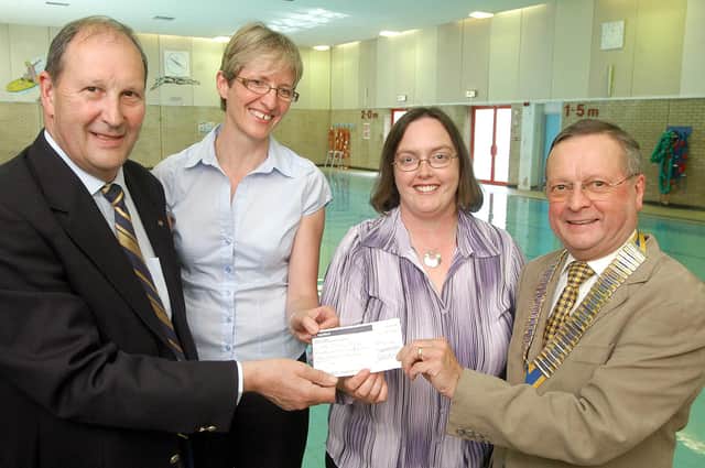 Mike Neville, left, and Mansfield Rotary Club president,  Ray Malkowski,  present a £1552.60 cheque to Michele Pulford, second left, the NCC School Swimming manager and Sandra Warner manager of Rainworth Social Enterprise. The money was used to buy disabled access steps for the community pool.