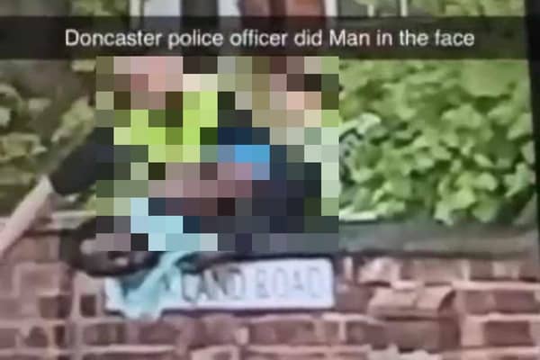 The clip appears to show a black man being repeatedly struck in the face by a police officer.