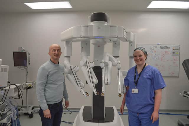 Patient Michael pictured with the Da Vinci Surgical XI robot and DBTH surgeon.