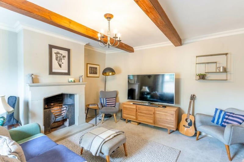 A beamed reception room with feature fireplace.