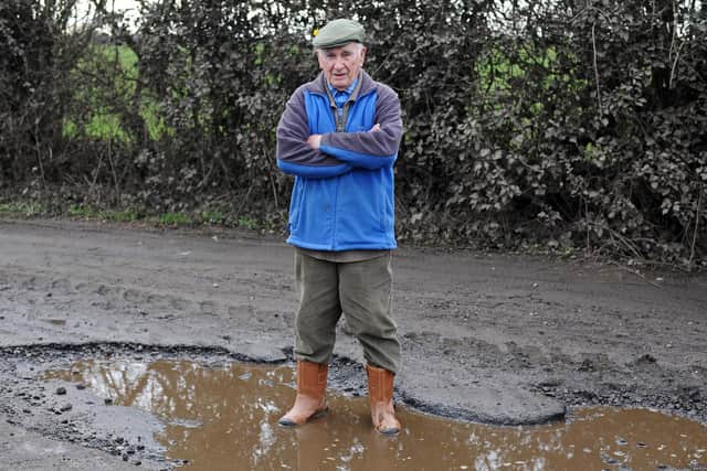 John Brown, Hatfield Parish Councillor, pictured in the Pot Hole on Hollin Bridge Road. Picture: NDFP-23-02-21-PotHole 1-NMSY