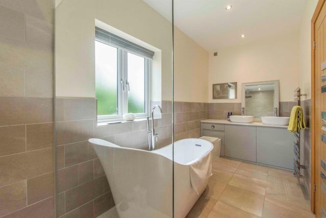 A luxurious bathroom with slipper bath and built-in vanity unit.