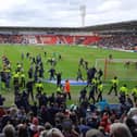 Ecstatic Doncaster Rovers fans invade the pitch during the game with Barrow.