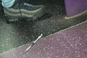 The syringe on the floor of the school bus.