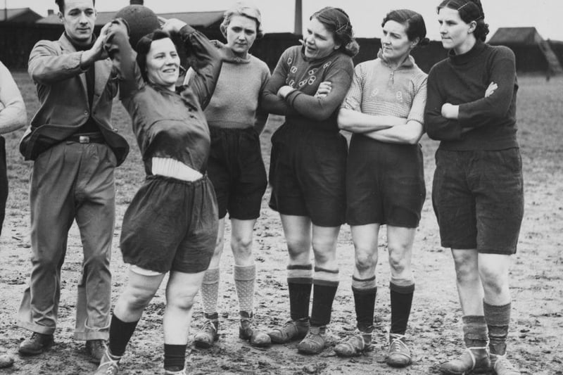 Footballers for the Edlington Women's Football Team receive instructions from coach James Bott on the technique of a throw in during a training session on 22nd May 1939 at the playing fields in Edlington.