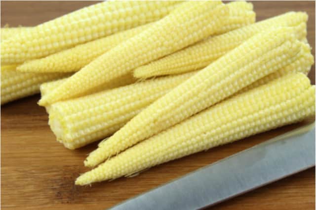 A woman was jailed for stabbing a neighbour who threw sweetcorn at her house.