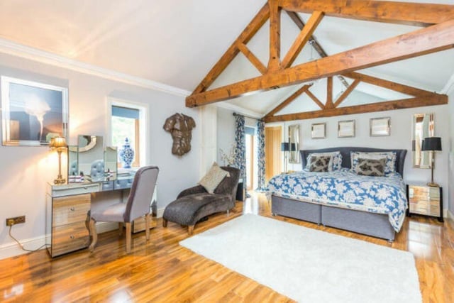 A bedroom with vaults and exposed beams to the ceiling, and exceptional floor space.
