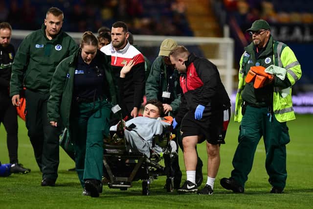 Doncaster Rovers' Louie Marsh is taken off on the stretcher after breaking his arm.