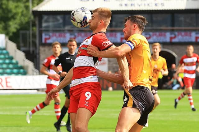 Doncaster Rovers' George Miller shields the ball from Newport County's Ryan Delaney.