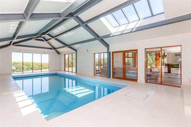 The property benefits from a heated indoor swimming pool, with picture windows and folding doors leading into the garden, an automatic cover, wave machine, and changing and shower facilities.