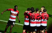 Doncaster's players celebrate Harrison Biggins' goal.