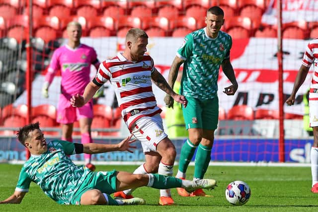Adam Clayton is challenged by Swindon's Jacob Wakeling. Picture: Andrew Roe/AHPIX LTD