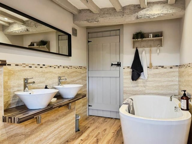 A stylish bathroom with twin washbasins and freestanding bath.