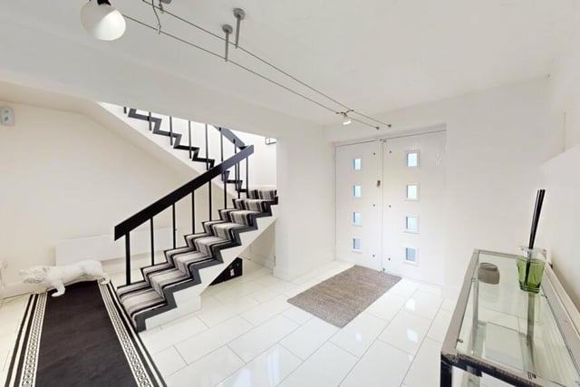 The sleek hallway with feature open staircase.