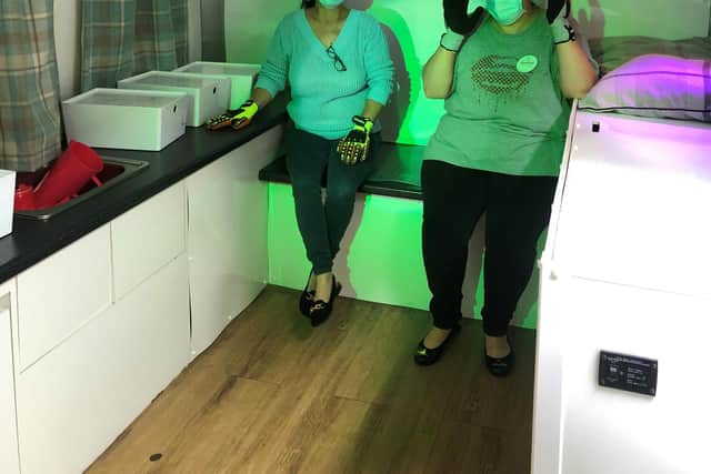 Shift leaders Melanie Hough and Shelley Bogan inside the Autism Bus, wearing headsets, glasses and gloves to alter her perception and be transported into the sensory experience.jpg