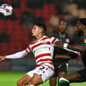 Doncaster's Kyle Knoyle is closely followed by a Walsall defender.