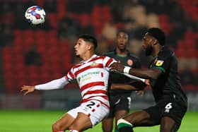 Doncaster's Kyle Knoyle is closely followed by a Walsall defender.