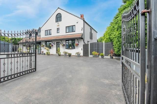 The gated frontage of the stand-out property in a village location.
