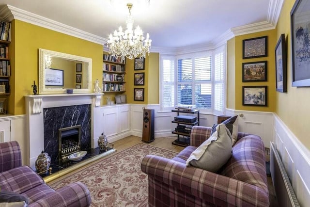 Another bay-windowed room with period decor features and stunning fireplace.