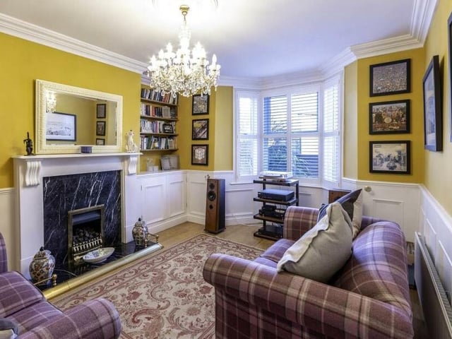 Another bay-windowed room with period decor features and stunning fireplace.