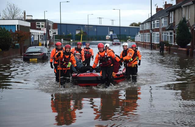 Members of the Fire and Rescue service evacuate an elderly resident to dry land, from a flooded house in Bentley in 2019