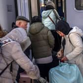 Ukrainian refugees board a train en route to Warsaw at the railway station in Przemysl, near the Polish-Ukrainian border, on March 27, 2022, following Russia's invasion of Ukraine about one month ago. - More than 3.8 million people have fled Ukraine since Russia's invasion a month ago, UN figures showed on March 27, 2022, but the flow of refugees has slowed down markedly. The UN refugee agency, UNHCR, said 3,821,049 Ukrainians had fled the country -- an increase of 48,450 from the figures on March 26. Around 90 percent of them are women and children, it added. (Photo by Angelos Tzortzinis / AFP) (Photo by ANGELOS TZORTZINIS/AFP via Getty Images)