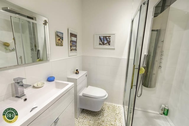 A modern shower room with walk-in shower, and wash basin vanity unit.