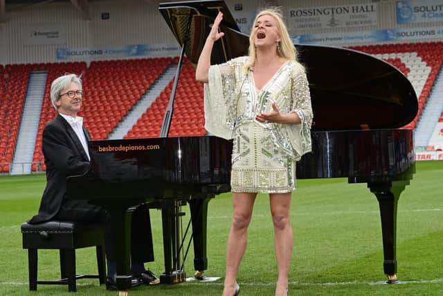 Rachael Wooding pictured performing on the pitch at the Keepmoat Stadium, with Pianist John G Smith. NDFP-27-04-21-LiveMusicReturn 3-NMSY