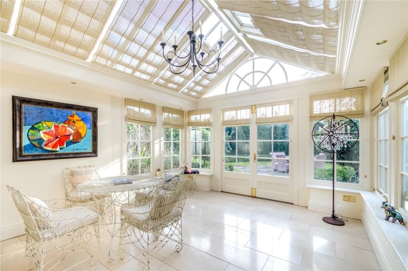 A stunning conservatory with double doors leading out to the gardens.