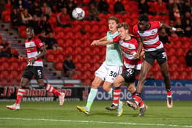 Mo Faal (far right) heads at goal for Doncaster Rovers