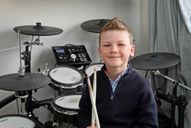 Jared Farmer, seven, pictured by his Electric Drums.